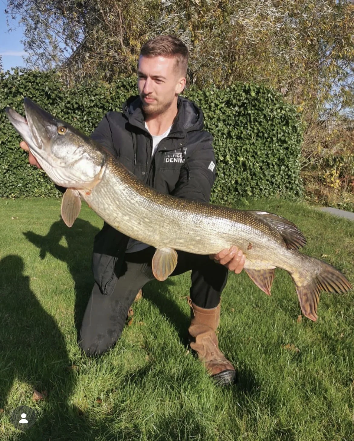 Wytse Punter met een trofee-snoek op een Nederlandse grasoever in laat herfstlicht
