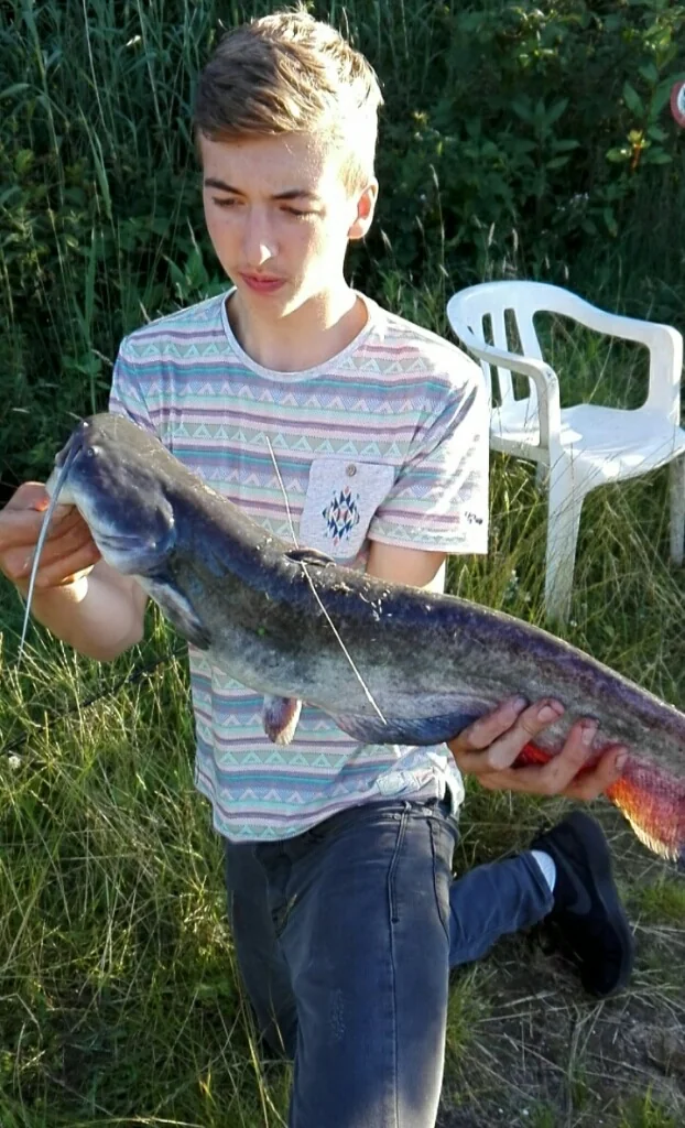 Jonge Wytse Punter met een meerval in avondlicht