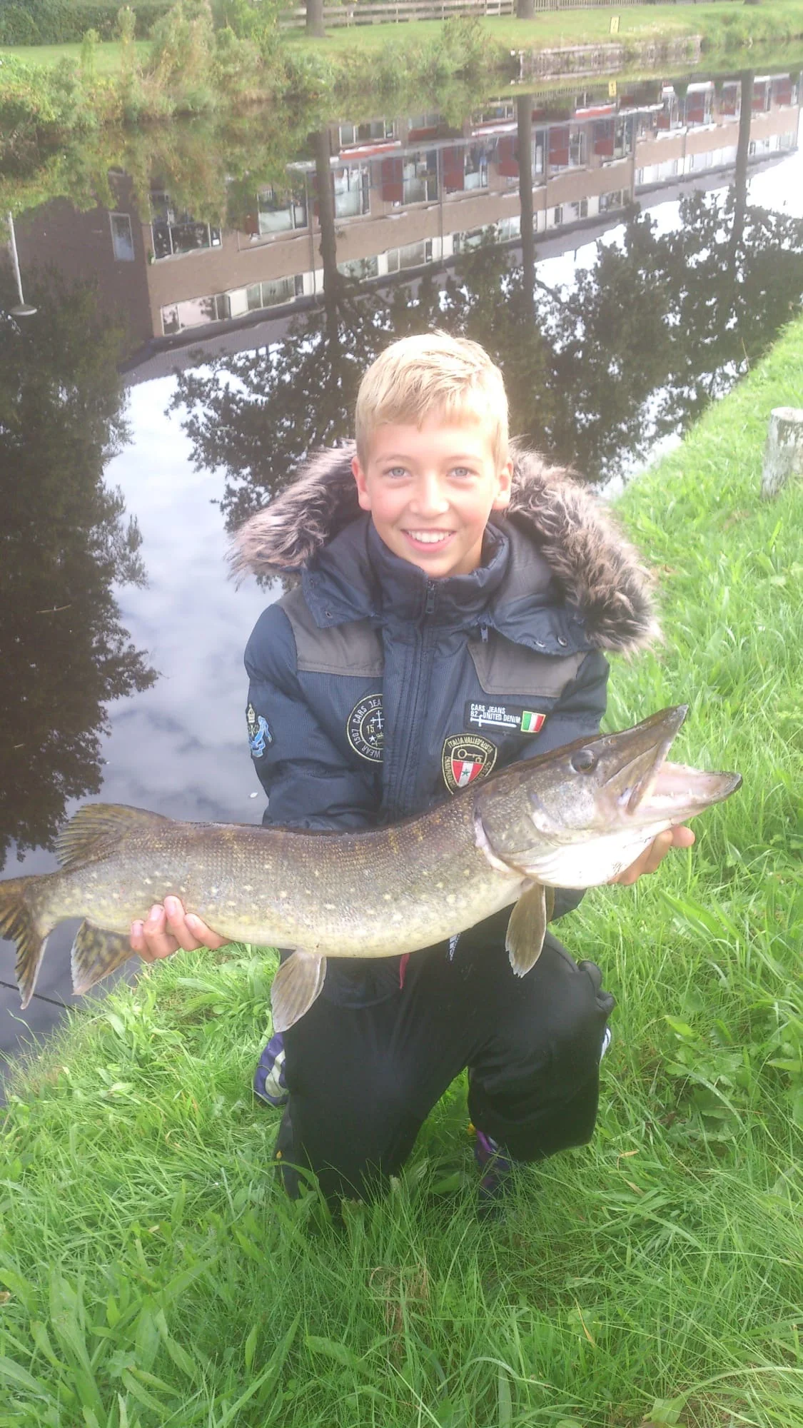 Tienjarige Wytse Punter met een snoek aan een winterse kanaaloever in Nederland